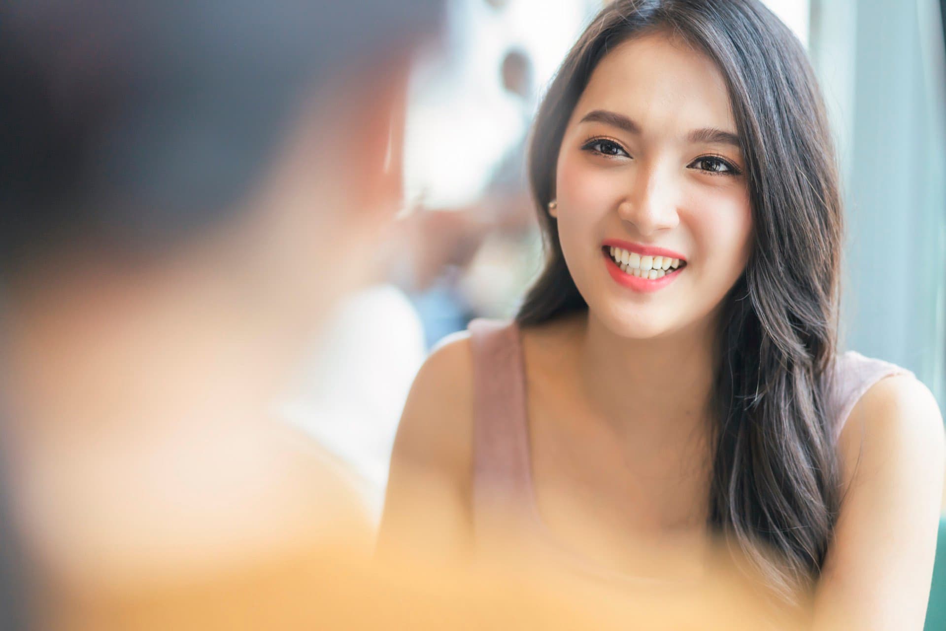 Smiling woman seated at a table during a conversation