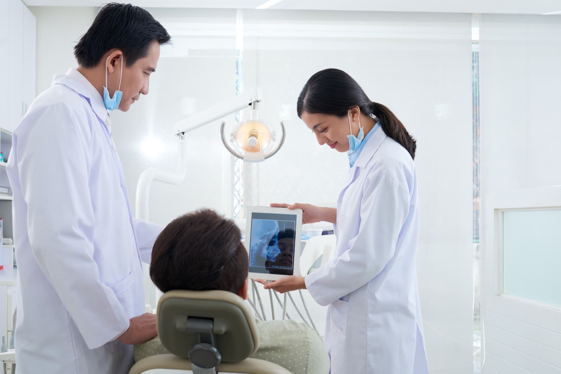 Dentist reviewing gum health findings with a patient on a tablet X-ray